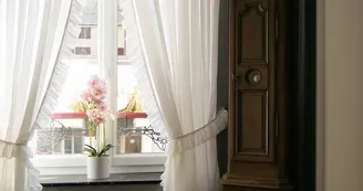 Couloir donnant sur une fenêtre et une horloge comptoise